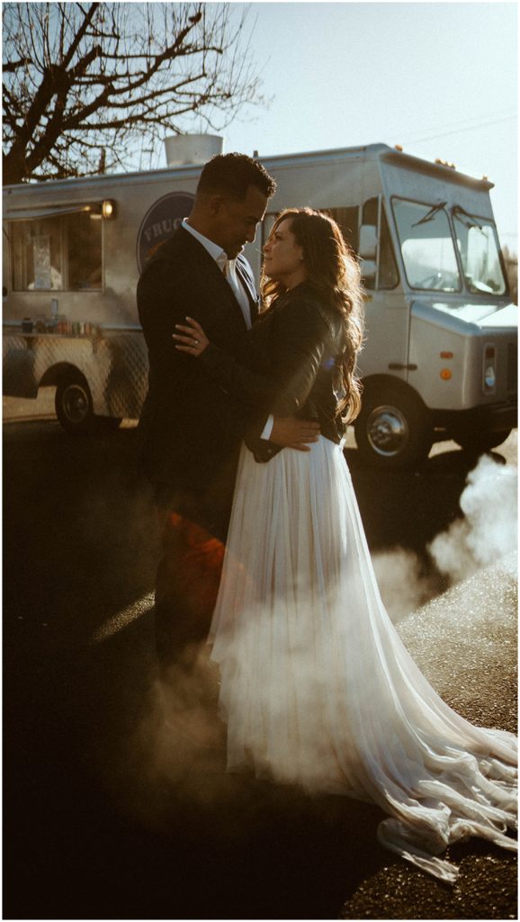 bride and groom hugging in front of food truck