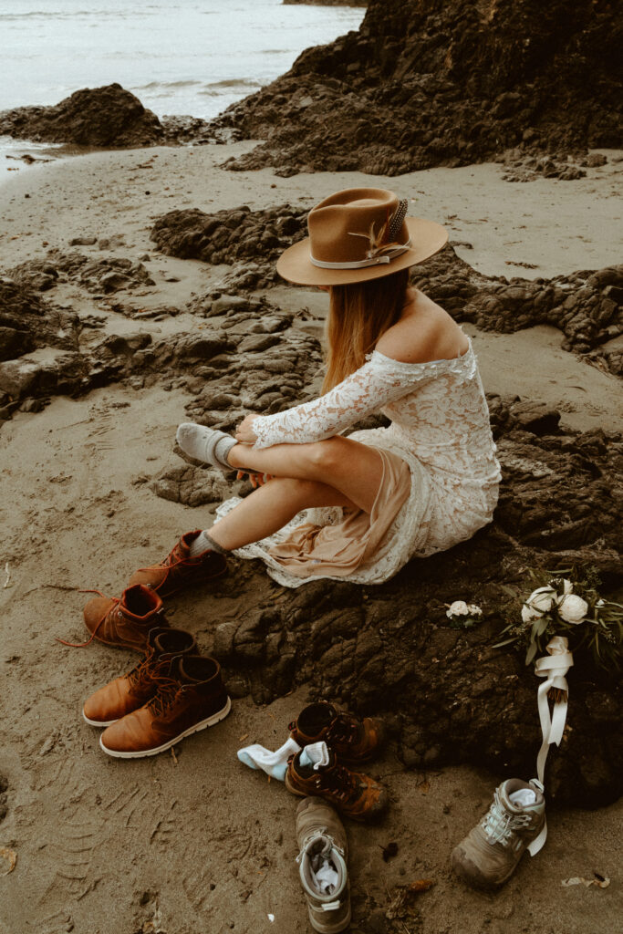 bride putting on her boots during an elopement at Salt Creek in the PNW