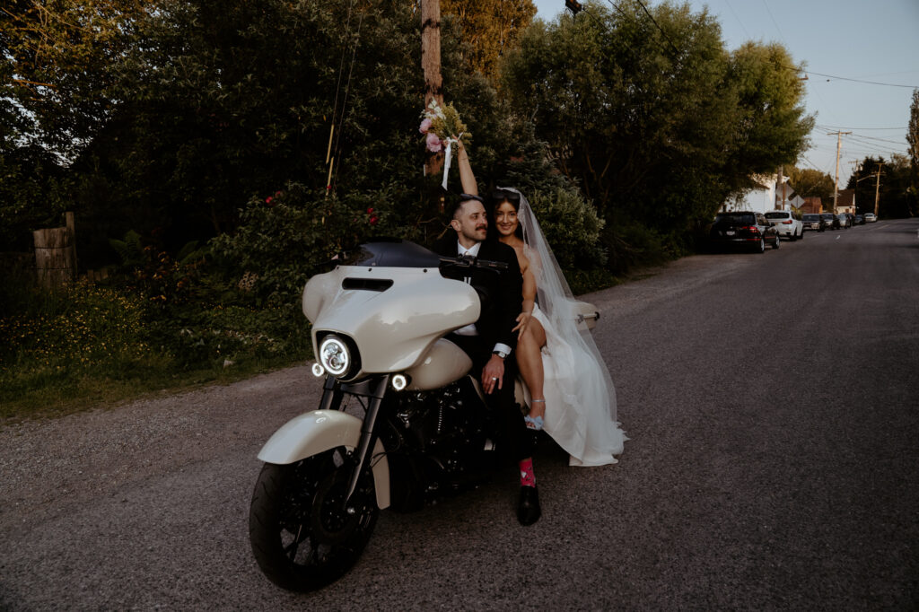 bride and groom exit on harley davidson down rural road