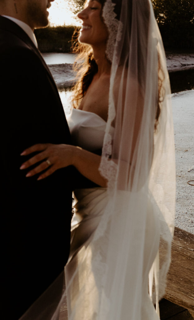 Bride and groom holding hands on waterfront dock