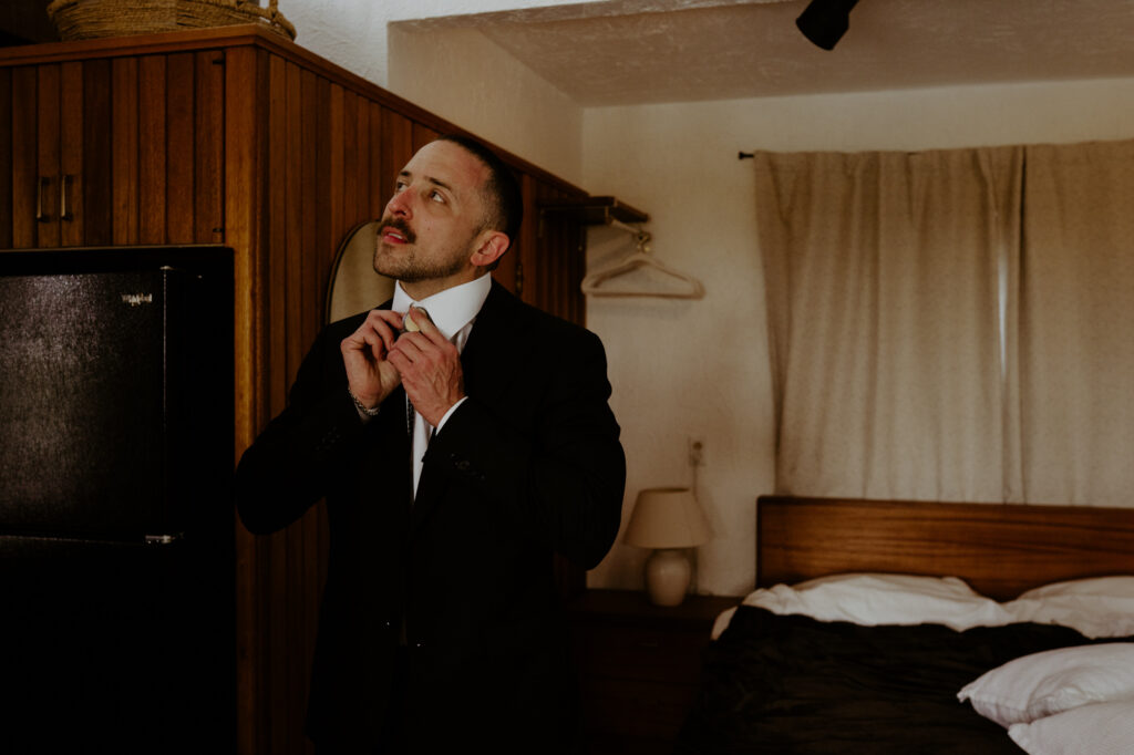 Groom adjusting tie before micro wedding ceremony