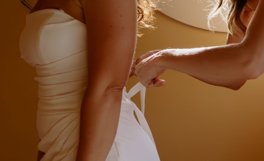 Bride's dress being laced up