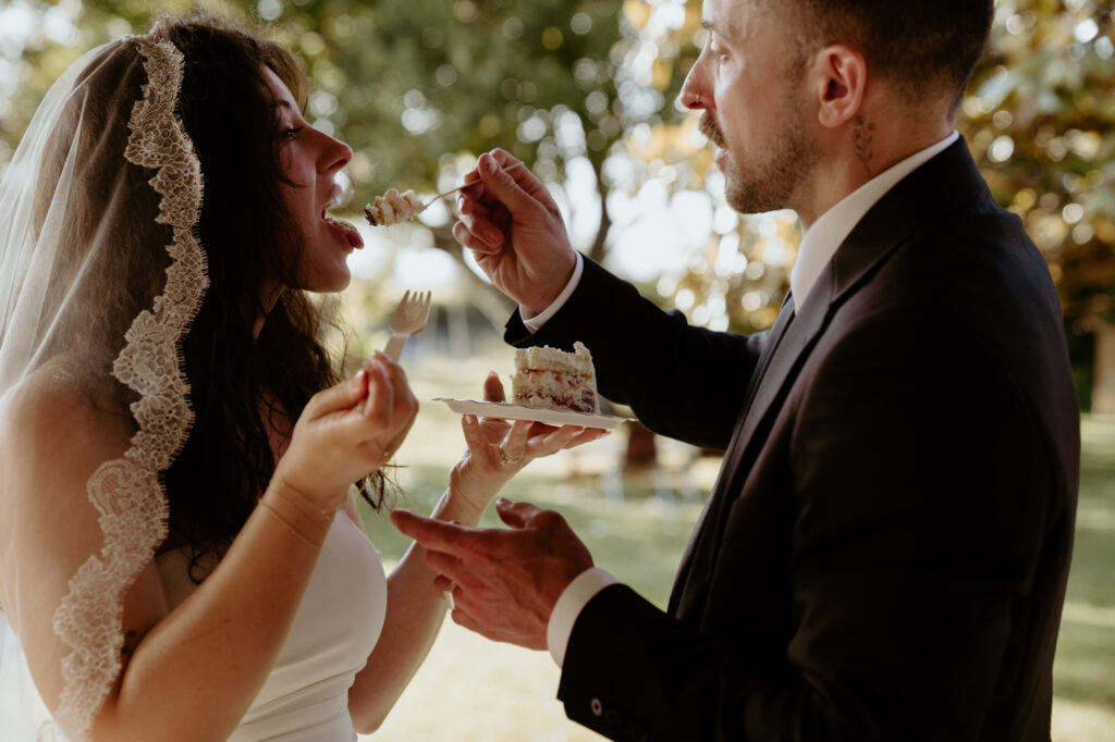bride and groom feeding each other wedding cake