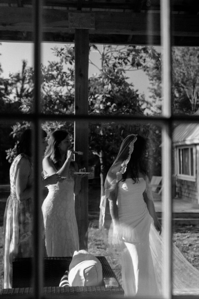bride and bridesmaids seen through old window pane of farmhouse