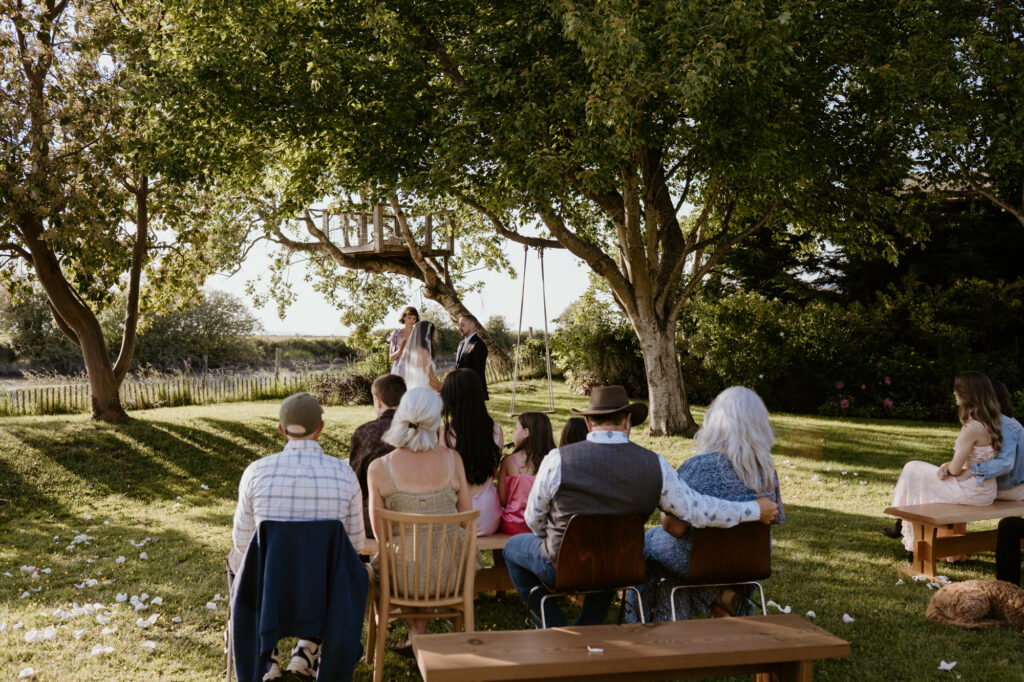 Guests watching intimate waterfront ceremony