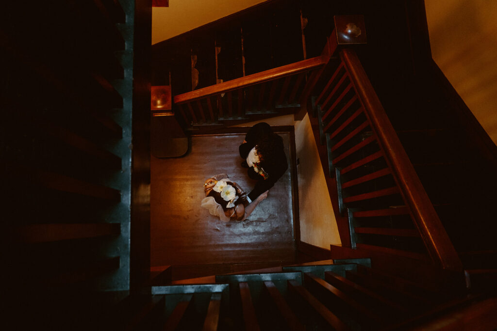 wedding couple at the bottom of wooden staircase