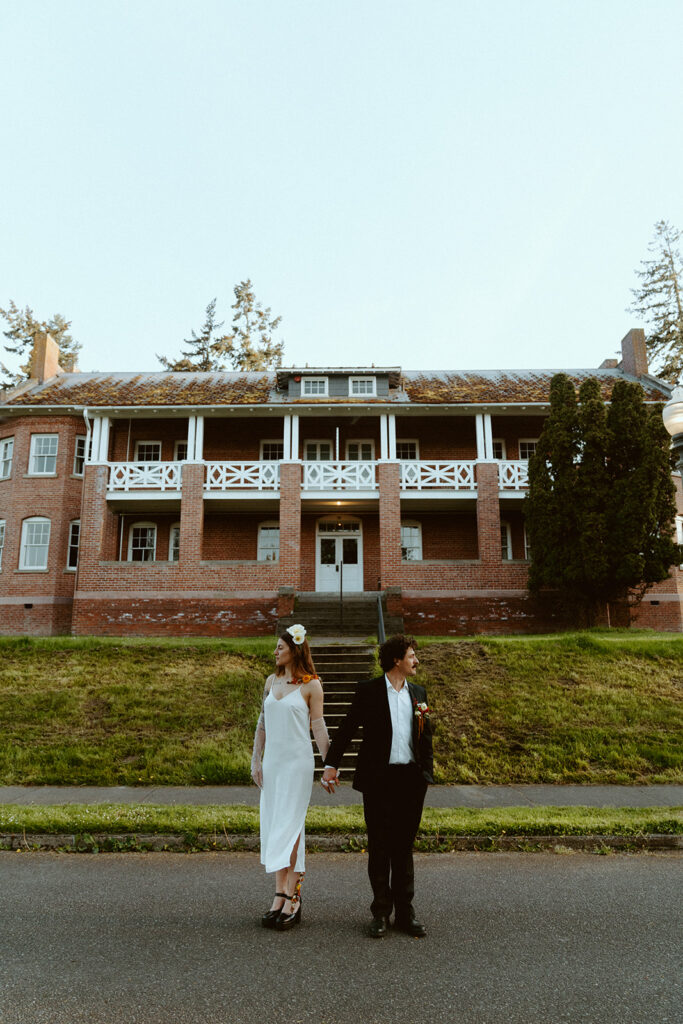 couple in wedding attire posing at fort worden state park