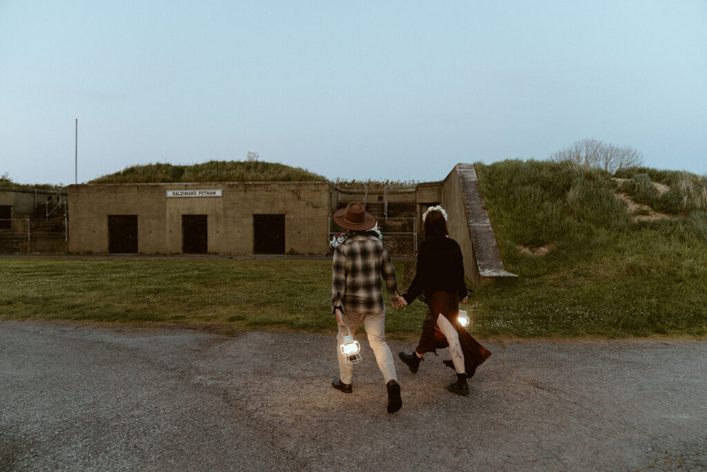 wedding couple carrying lanterns at dusk
